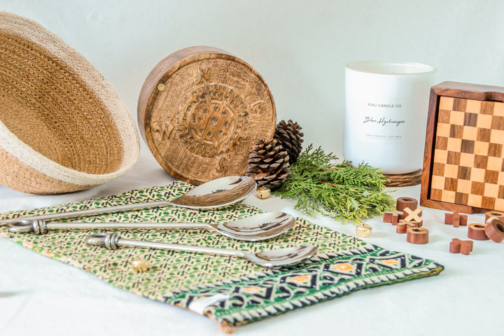 Ethical gifts for the home set including jute bowl, handmade green placemat, serving spoons, wooden game set, trinket box and soy candle